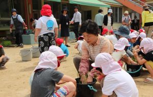 園児らに植え方を教える女性部の中谷さん